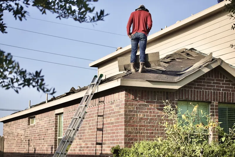 Professional roofer working on a residential roof in Brook Farm